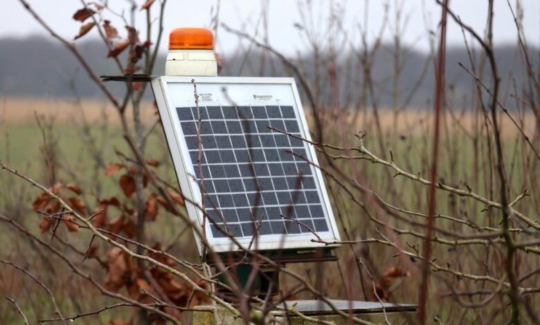 A solar panel mounted to a pole in a field
